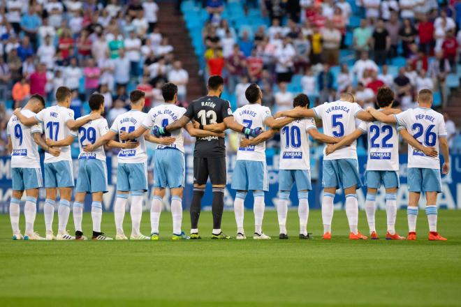 Los jugadores del Real Zaragoza se abrazan durante el minuto de silencio en memoria de José Antonio Reyes. (Foto: Dani Marzo).