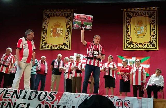 Manolo Delgado alza el recuerdo conmemorativo que la Peña Gainza le concedió en su homenaje (Foto: Athletic Club).