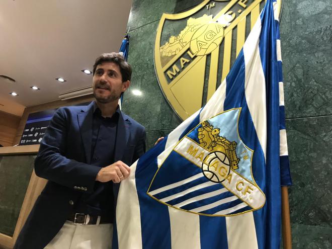 Víctor posa junto a la bandera del Málaga.