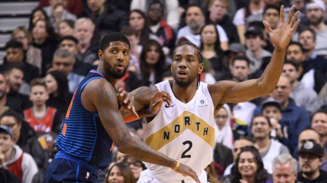 Paul George y Kawhi Leonard pelean por un balón.