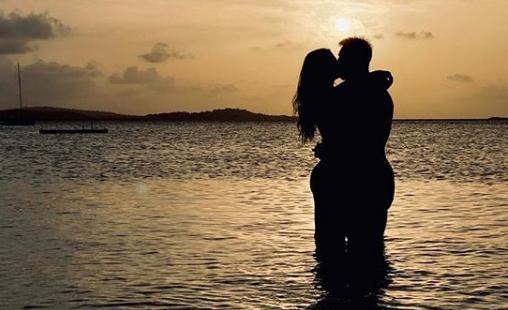 Leo Messi y Antonela Roccuzzo se dan un beso en la playa durante la puesta de sol (Foto: @antonelaroccuzzo).