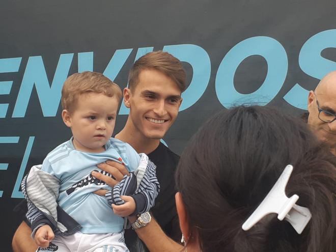 Denis Suárez posa con un niño tras firmar autógrafos en A Madroa.