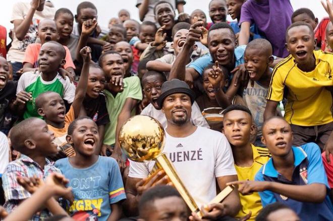 Serge Ibaka posa con un grupo de niños congoleños y el trofeo de campeón de la NBA (Foto: @sergeibaka).
