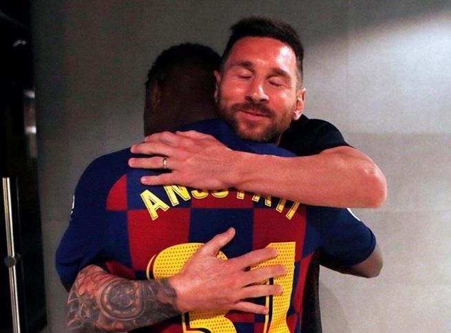 Leo Messi se abraza con Ansu Fati tras el debut de este último.