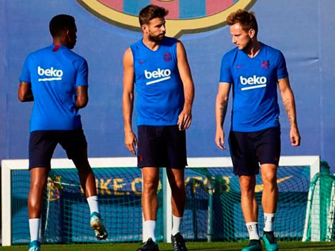 Rakitic y Piqué hablan en un entrenamiento del FC Barcelona.