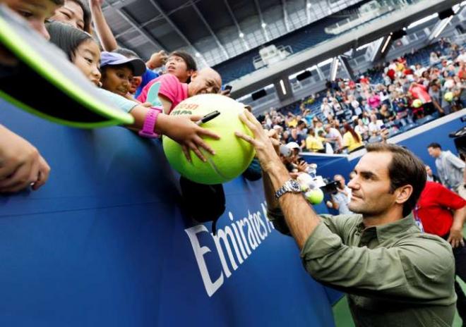 Roger Federer firma autógrafos a sus seguidores en el US Open (Foto: EFE).