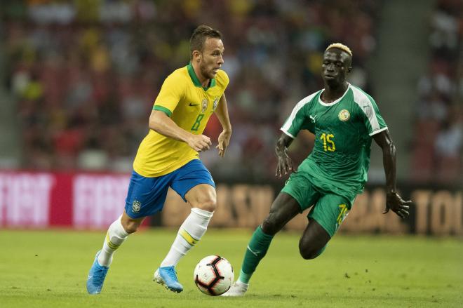 Arthur conduce el balón ante la presión de un jugador de Senegal.