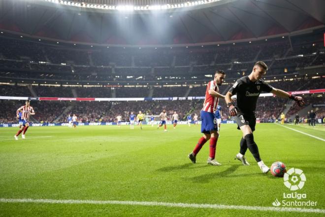Unai Simón juega con los pies presionado por un rival del Atlético en el Wanda (Foto: LaLiga).