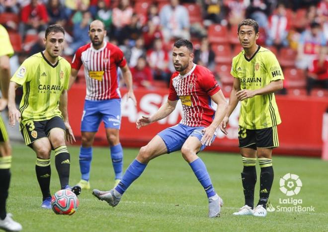 Javi Fuego pugna la pelota con Lasure en el Sporting-Zaragoza (Foto: LaLiga).