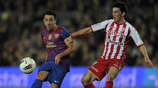 André Castro presiona a Xavi durante un Barça-Sporting.