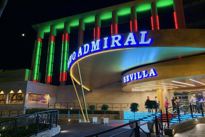 La fachada del Casino Admiral Sevilla se ilumina con los colores verde y rojo por el derbi.