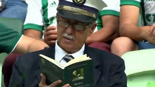 Aficionado leyendo a Karl Marx durante el partido del Palmeiras.