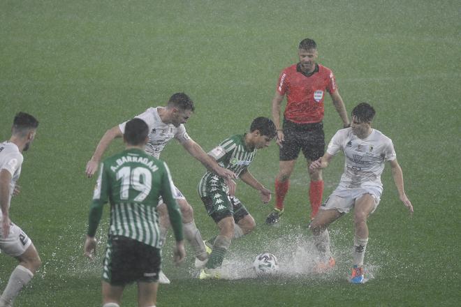 Diego Lainez intenta regatear entre un charco de agua a dos jugadores del Antoniano en el partido de la Copa del Rey (Foto: Kiko Hurtado).