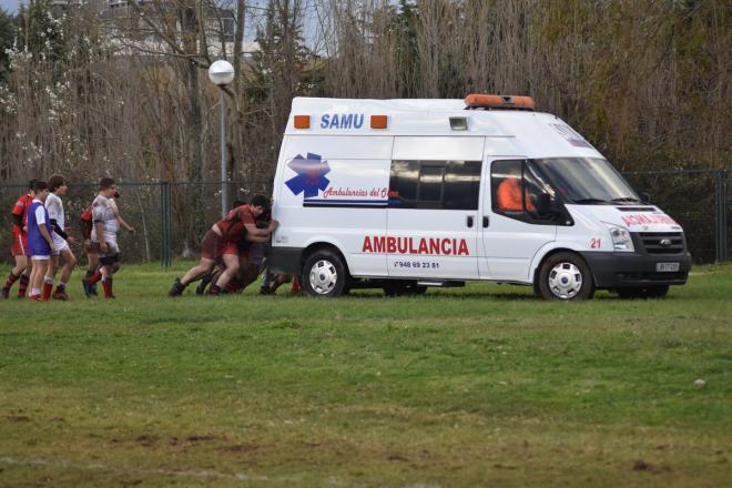 Los jugadores de Cantabria y Navarra sub 16 se unen para sacar una ambulancia del terreno de juego.