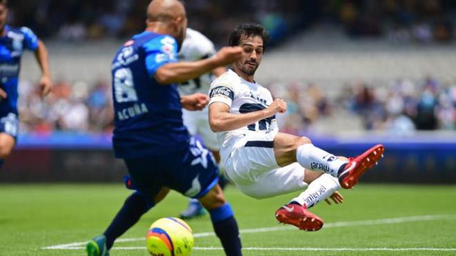 Alejandro Arribas pelea un balón con el Pumas.