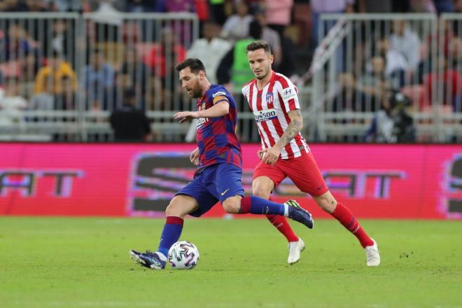 Leo Messi se lleva el balón ante la presión Saúl.