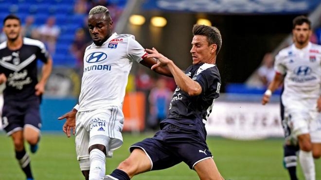 Maxwel Cornet y Laurent Koscielny pugnan por un balón.