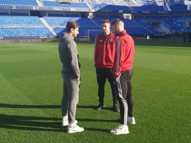 Luis Muñoz dialoga con dos jugadores del Mirandés.