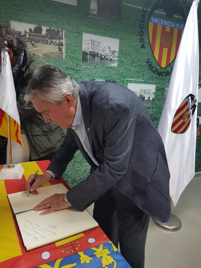 Roberto Gil, excapitán del Valencia CF, firma durante el homenaje.