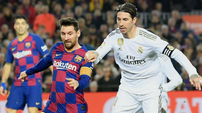 Leo Messi y Sergio Ramos pelean por un balón durante un partido de fútbol.