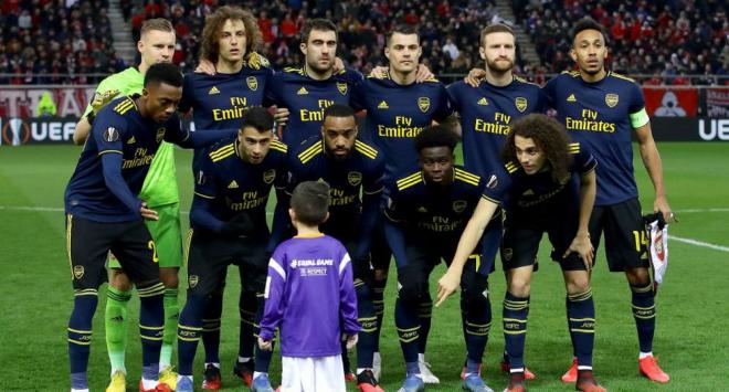 Los jugadores del Arsenal le dice a un niño que estaba desorientado que pose con ellos en la foto.