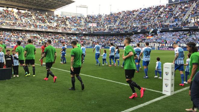 Los jugadores del Málaga y el Racing saltan al césped de La Rosaleda.