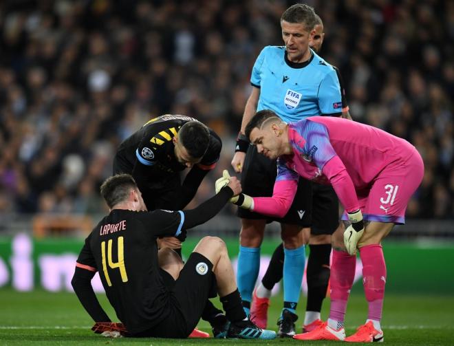 Ederson ayuda a Laporte a levantarse tras caer lesionado en el Bernabéu.