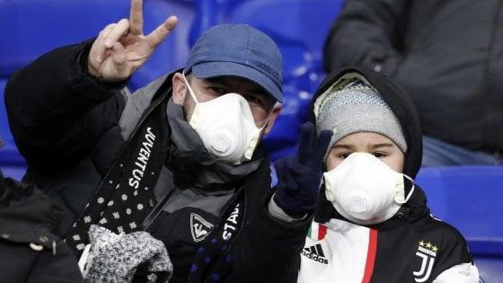 Dos aficionados de la Juventus, con mascarillas para protegerse del coronavirus.
