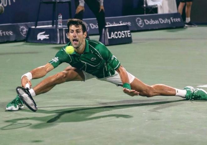 Novak Djokovic se estira en el torneo de Dubái.
