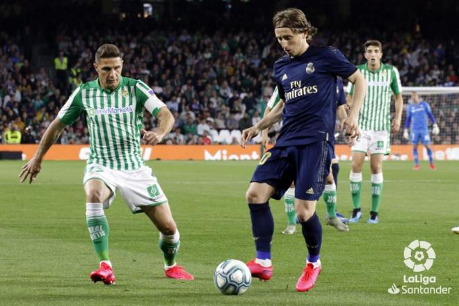 Modric conduce el balón ante la presión de un adversario.