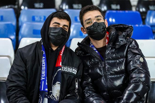 Aficionados con mascarilla en un estadio ante la amenaza del coronavirus.