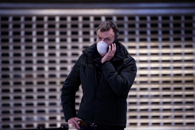 Un pasajero que se protege del coronavirus habla por teléfono en el Aeropuerto de Málaga, con el tráfico aéreo restringido. (Foto: EFE).