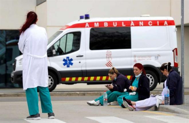 Varios sanitarios descansan en la puerta de un hospital (Foto: EFE).