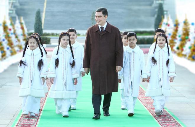 Gurbanguly Berdymukhamedov, presidente de Turkmenistán, camina junto a unas niñas.