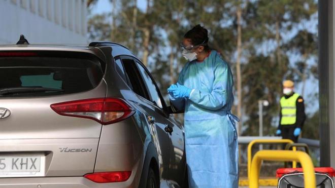 Un sanitario realiza un test rápido desde el exterior del coche de un ciudadano (Foto: EFE).
