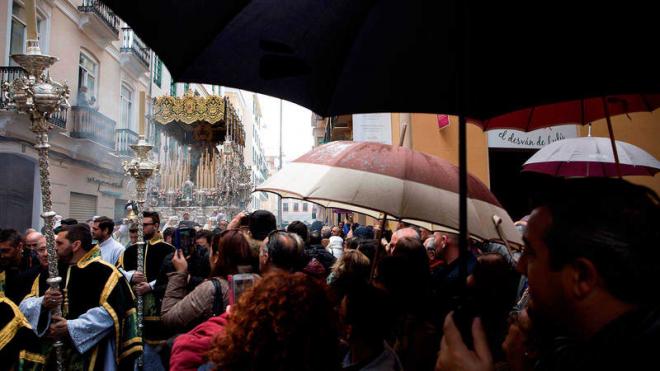 La gente ve bajo la lluvia el paso de Lágrimas y Favores el pasado Domingo de Ramos (Foto: EFE).