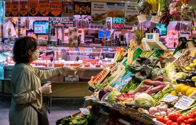 Imagen de una mujer comprando en un mercado.