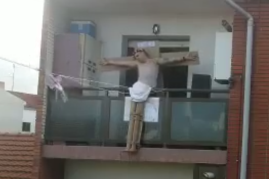Un vecino representando en su balcón a Jesuscristo crucificado.