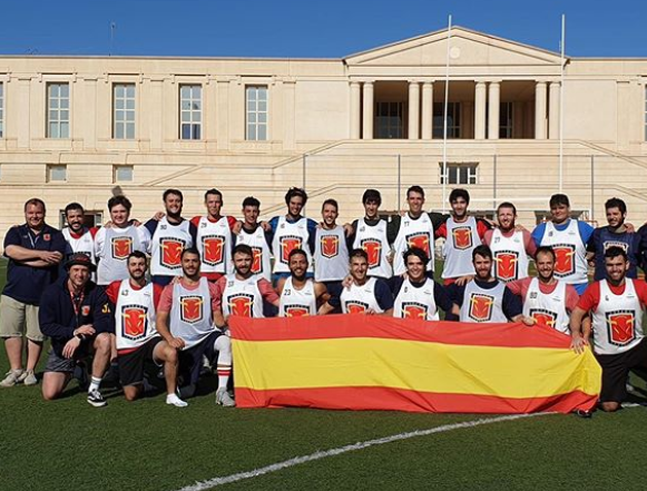 La selección española de lacrosse posa con la bandera durante una concentración.