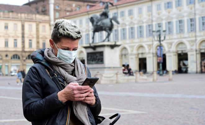 Una señora utiliza el móvil en una plaza en plena pandemia por el coronavirus.