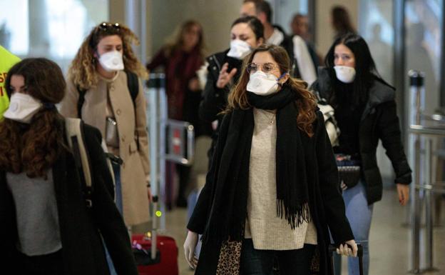 Varias personas llegan al aeropuerto con mascarillas (Foto: EFE).
