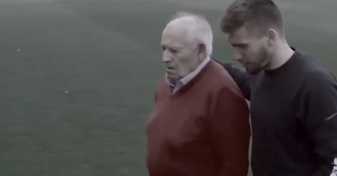 Imagen de Portu paseando con su abuelo por un campo de fútbol.