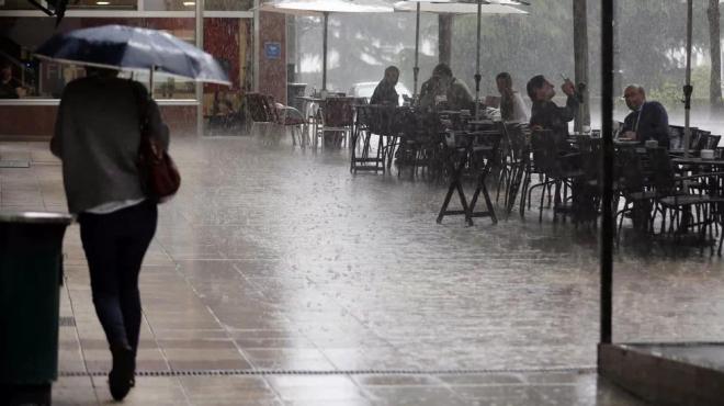 Día lluvioso con gente en las terrazas.