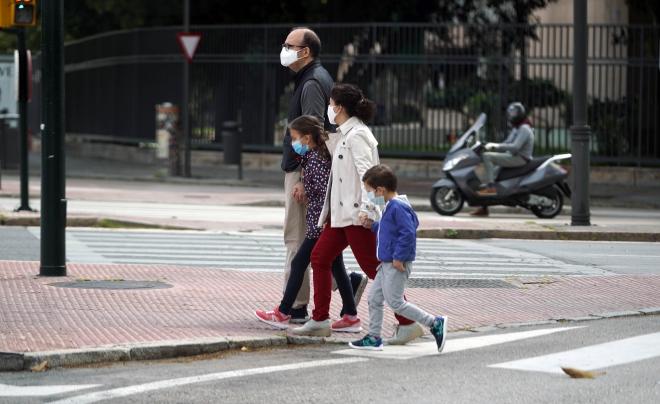 Un padre pasea con sus hijos.