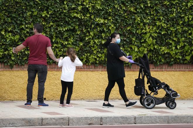 Paseo de una familia con sus hijos, ataviados con mascarillas.