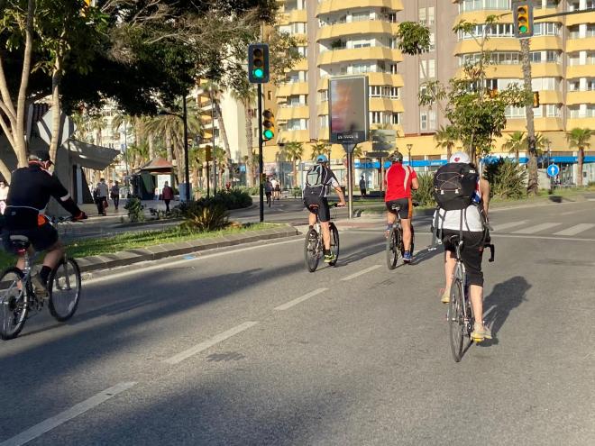 Varias personas, paseando en bicicleta por las calles de Málaga.