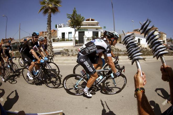 Un aficionado sujeta unos espetos al paso de la Vuelta por Málaga en ediciones anteriores.