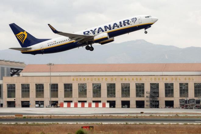 Un avión, sobrevolando el aeropuerto de Málaga (Foto: EFE).