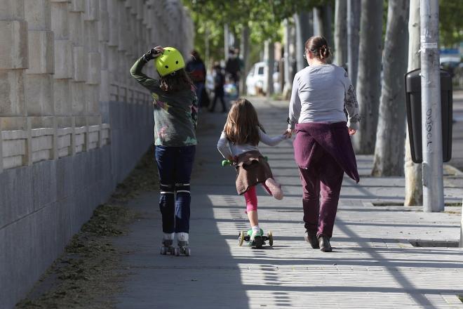 Un adulo pasea con dos niños en el Parque Santander de Madrid (FOTO: EFE).