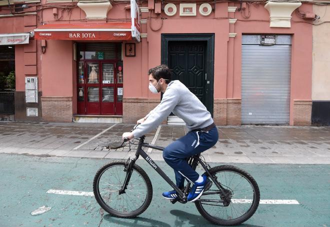 Un hombre va en bicicleta por Sevilla con mascarilla en tiempos de coronavirus (Foto: Kiko Hurtado).